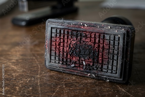 Macro close up of a rubber office stamp with dried red and black ink residue