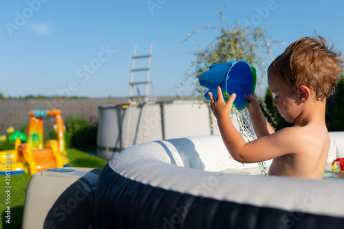 Little boy playing in outdoor inflatable jacuzzi