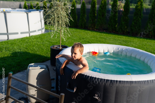 Young boy enjoying summer fun in inflatable hot tub
