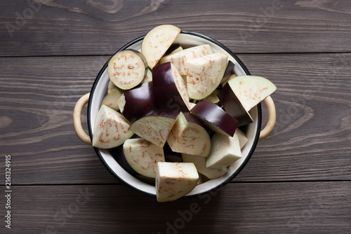 Chopped ​​eggplants in saucepan on wooden table