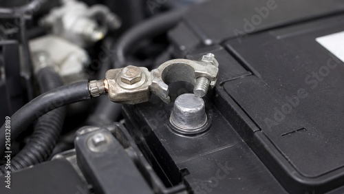 Close-up of automotive battery terminal showing loose cable clamp sitting improperly around battery post, realistic electrical maintenance defect discovered during inspection
