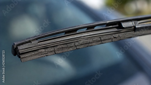 Macro close-up of aging windshield wiper blade showing cracked and deteriorated rubber edge