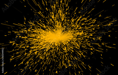 Cuadro en lienzo Bright orange sparks bursting outward against a stark black background