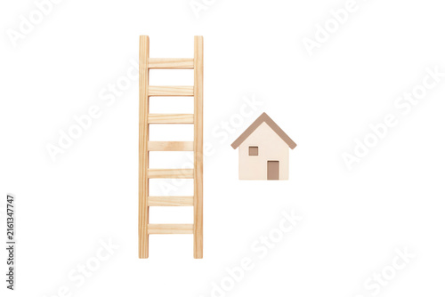 A wooden ladder stands tall next to a small house symbol, representing home improvement and growth