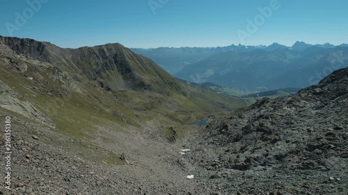Smooth aerial video capturing rolling mountains and bright sunshine in summer.