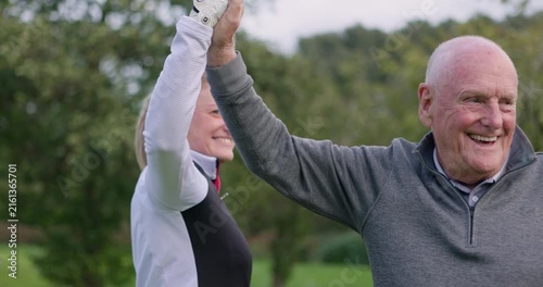 Man, woman and high five at golf course, celebration and talking with fitness, outdoor and teamwork. Elderly person, coaching and retirement with goals, workout and congratulations for achievement