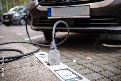 Ein E-Auto wird an einem Ladebordstein auf der KÖ mit einem Kabel aufgeladen, Düsseldorf, Deutschland