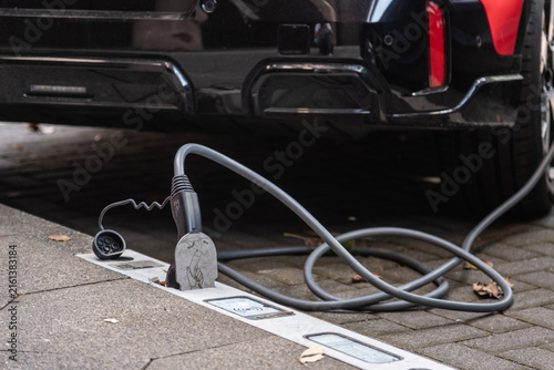 Ein E-Auto wird an einem Ladebordstein auf der KÖ mit einem Kabel aufgeladen, Düsseldorf, Deutschland