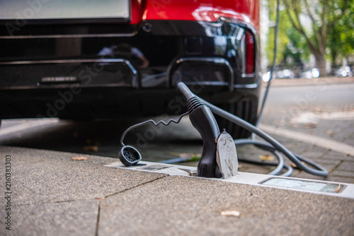 Ein E-Auto wird an einem Ladebordstein auf der KÖ mit einem Kabel aufgeladen, Düsseldorf, Deutschland