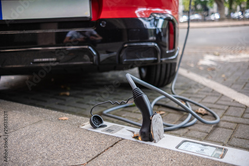 Ein E-Auto wird an einem Ladebordstein auf der KÖ mit einem Kabel aufgeladen, Düsseldorf, Deutschland