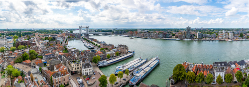 This panorama shows a view of the city of Dordrecht with the Oude Maas, the city of Zwijndrecht on the opposite bank and the railway bridge over the Oude Maas