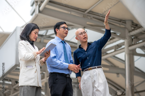 Korean female real estate agent pitching a lucrative downtown commercial property investment to a businessman, presenting valuable modern city skyscrapers 
