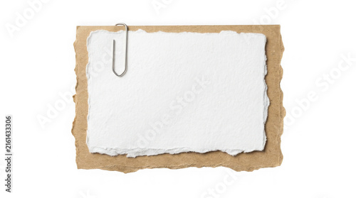Blank white paper with torn edges and metal clip on brown textured cardboard background