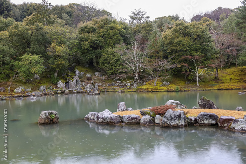 Japanese Zen Garden Pond with Rock Island and Rain Drops on Water Surface