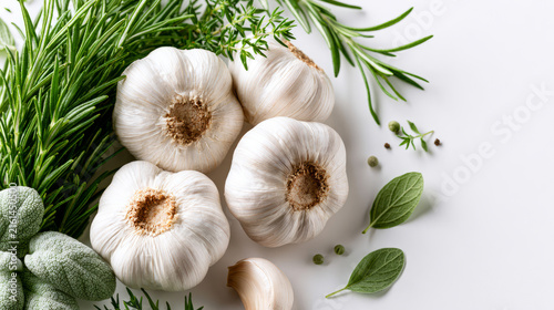 Fresh garlic and a variety of herbs displayed on a white background ideal for culinary and cooking inspiration