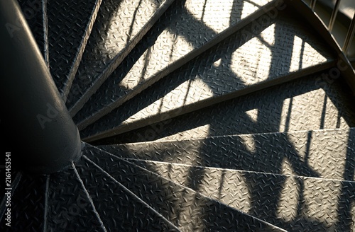 Industrial spiral staircase with diamond plate treads and patterned shadows