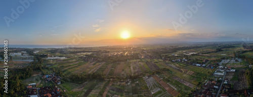 Foto Aerial Panoramic View of Rice Fields and Village Landscape at Golden Sunset