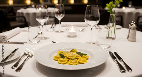 Elegant restaurant table setting with pasta dish and wine glasses