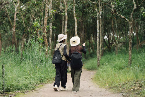 Konstfotografi female-hikers-pointing-direction-on-forest-trail.jpg
