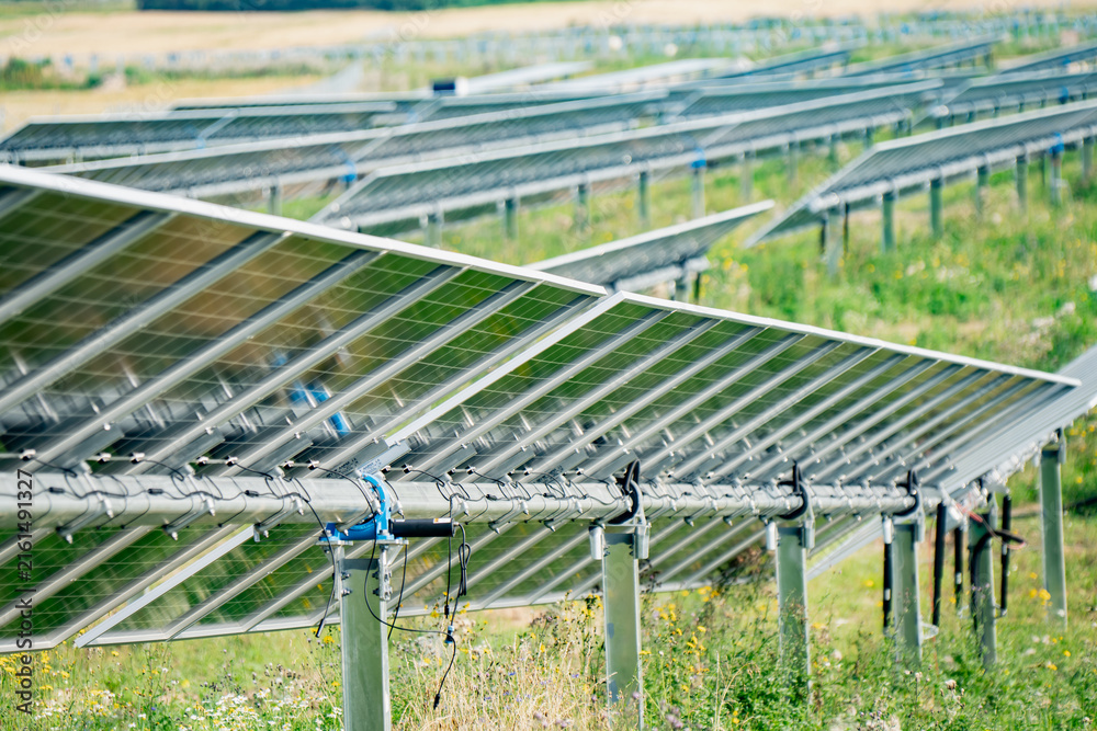 Fototapeta premium Motorized solar tracker mechanism with torque tube assembly and photovoltaic panel racking structure for renewable energy asset management