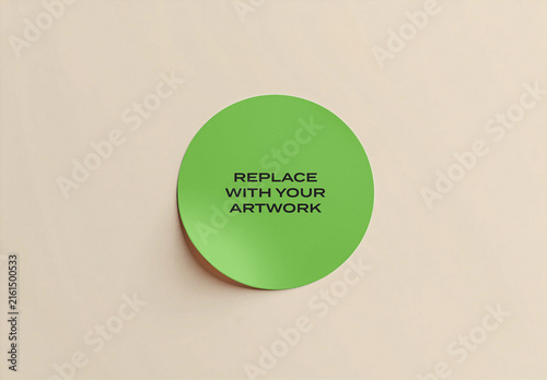 Circular sticker mockup on a neutral beige surface with text placeholder for artwork replacement, minimalist design template branding presentation, adhesive label display desk or wall