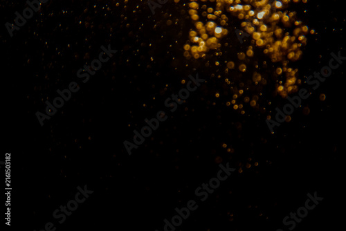 Blurred photo with golden dots visible glittering, shining brightly look and feel luxurious Suitable for use as a wallpaper