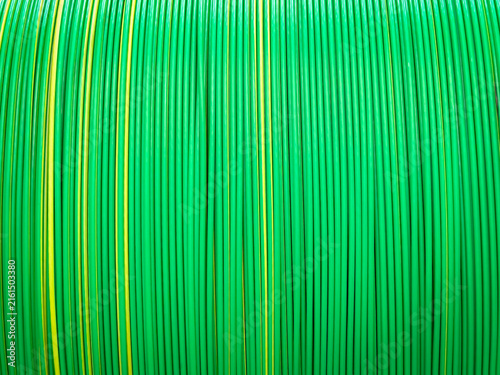 Vivid green and yellow plastic coated cables tightly coiled, showcasing a symmetrical and colorful pattern