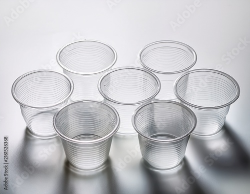 five empty clear plastic portion cups in a row on white background disposable food container packaging for takeaway and catering