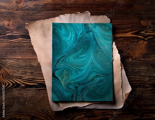 historical paper with teal marbled background on old wooden table