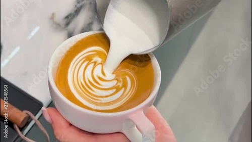 Barista Pouring Steamed Milk to Create Winged Heart Latte Art