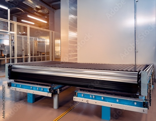 belt conveyor with a flat rubber belt and adjustable height for a packaging facility
