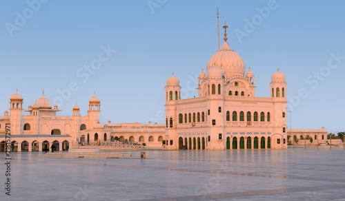 View of Gurdwara Darbar Sahib Kartarpur with its white domes and arches under a clear sky in Kartarpur, Punjab, Pakistan.