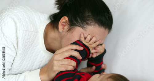 Cuadro en lienzo Authentic playful mother playing peekaboo with baby infant