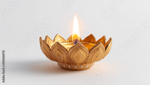 Small golden lotus shaped oil lamp with burning flame background festival tradition decoration ornament religious cultural spiritual celebration metallic isolated illumination wellness
