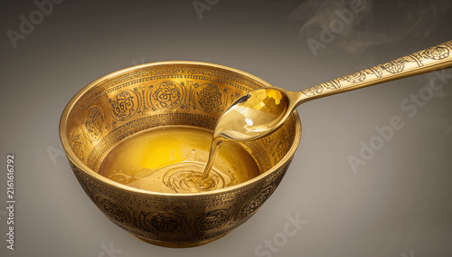 Traditional golden brass bowl filled with melted clarified butter ghee used in spiritual rituals clarified spiritual ceremony offering tradition practice religion traditional ingredient