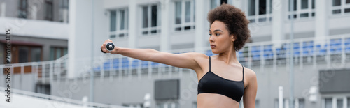 Fotografía Young woman exercising outdoors in vibrant sportswear with determination and str