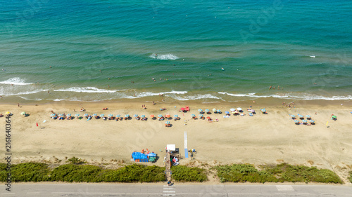 Bild auf Leinwand Aerial view of a sandy beach with colorful umbrellas, sunbeds and people relaxin