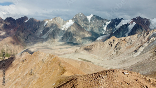 Drone view of Mynzhylky Plateau near Molodezhny Peak outside Almaty, Kazakhstan, with the surrounding mountain range and Tuyuk-Su and Molodezhny glaciers in the background.