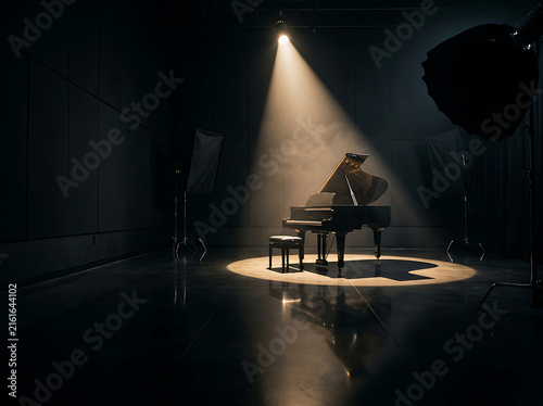 Grand piano on stage under dramatic spotlight in a dark music studio performance hall.