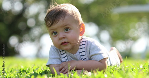 Canvas Print Baby child laid on grass outside in nature