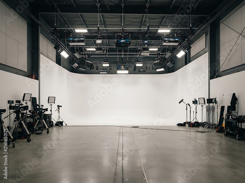 Professional empty photo studio with white cyclorama wall and overhead lighting equipment