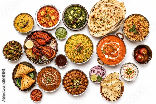 Top view of traditional Indian food dishes arranged on white background