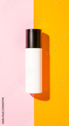 Spray can on vibrant pink and orange split background flat lay