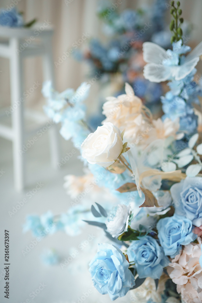Fototapeta premium Light blue and pastel pink floral arrangement with decorative butterfly wings on light background