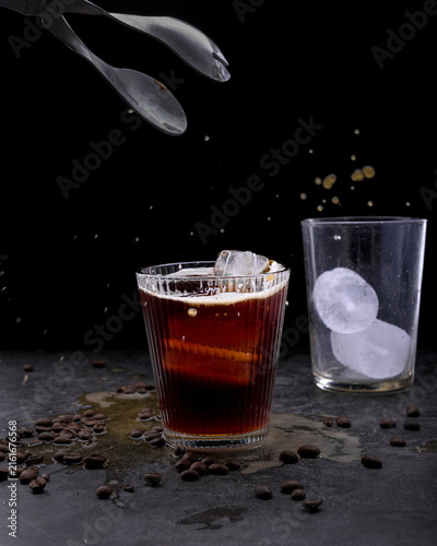 Foto Refreshing iced coffee cocktail with orange slice ice cubes vintage manual grind