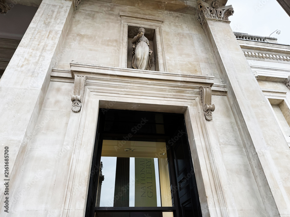 Fototapeta premium Entrance to the National Gallery in London, UK with classical stone facade and sculpture above doorway
