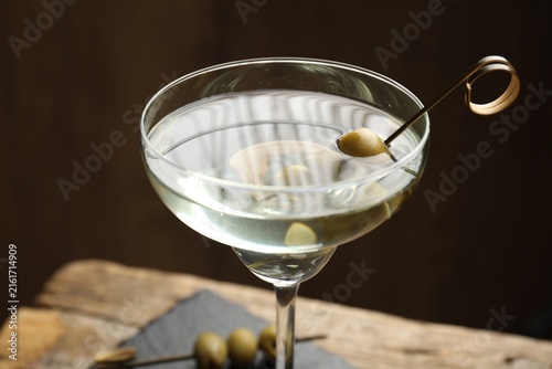Fotografie Martini cocktail in glass and olives on table, closeup