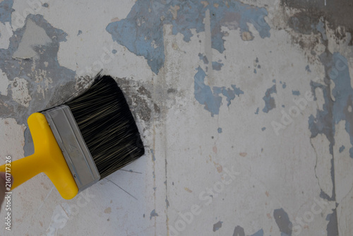 Fotografie Paint Brush Scraping Peeling Paint From Old Wall During Home Renovation And Prep
