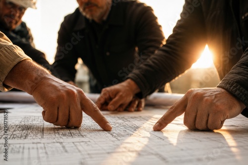 Engineers Collaborating on Technical Drawings in Professional Workspace
