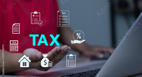 Obraz na płótnie Personal tax management, tax exemption, and investment deduction concept with hand holding glowing TAX text and floating financial category icons near laptop